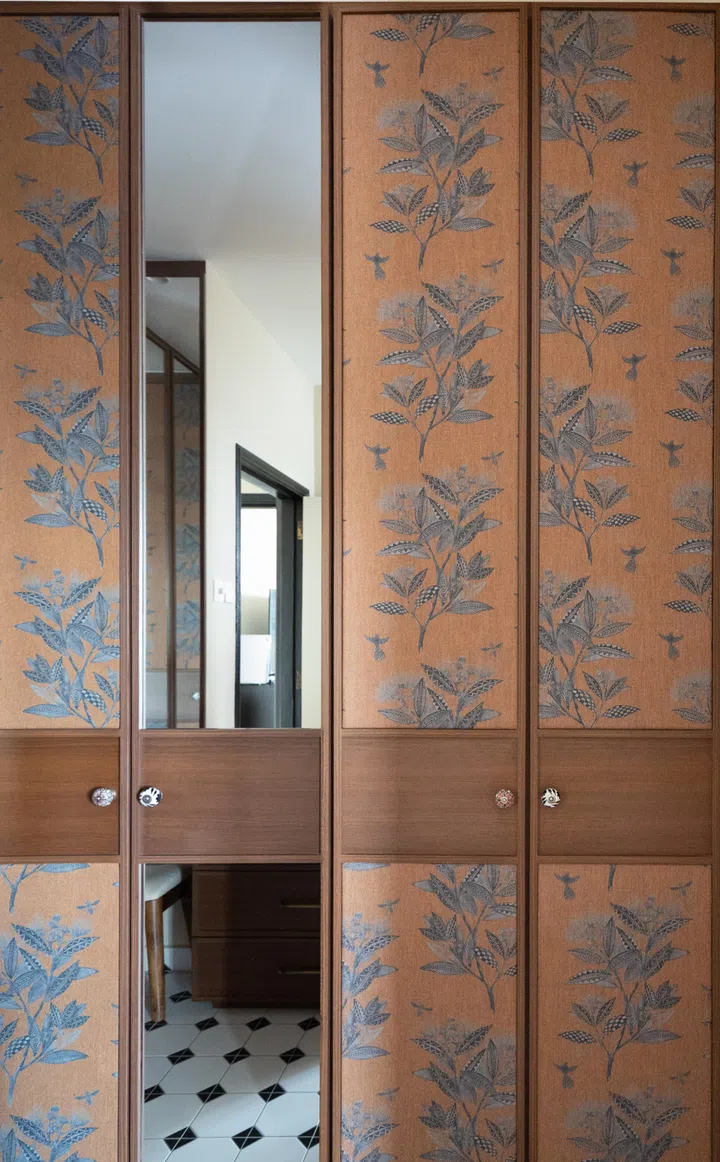 The couple’s closet is covered by fabric featuring hummingbirds and tropical flora. 