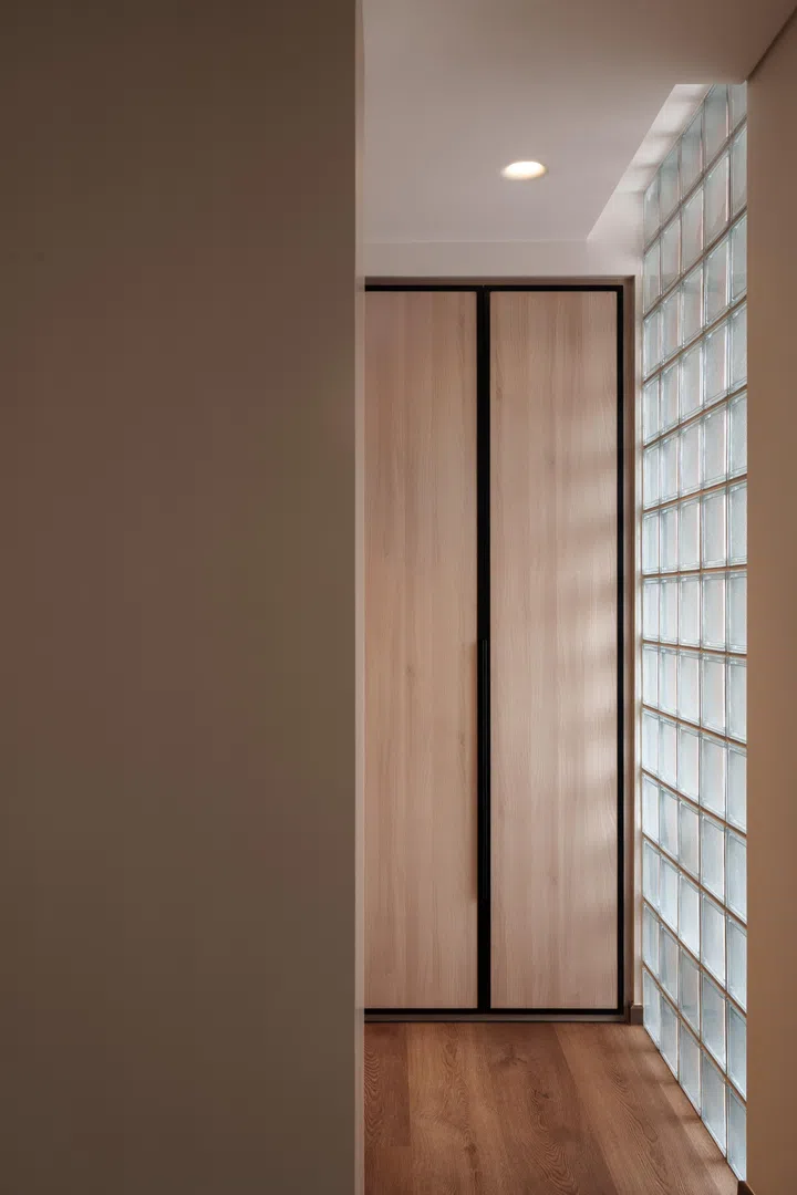 Glass blocks bring natural light into the walk-in wardrobe, continuing the home’s use of filtered light.