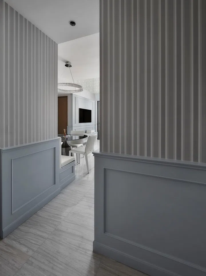 Wainscot walls and striped wallpaper run along the walls in a flight steward's 2-bedroom with study condominium along Sims Drive designed by The Cottage Crafts.