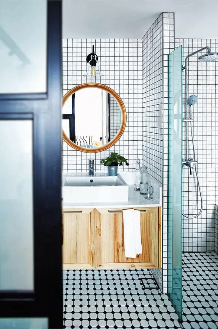 White mosaic tiles with black grouting are used in the master bathroom to give it a modern graphic appeal in this 3-bedroom condominium in Novena. Interior design by Museum Homes.