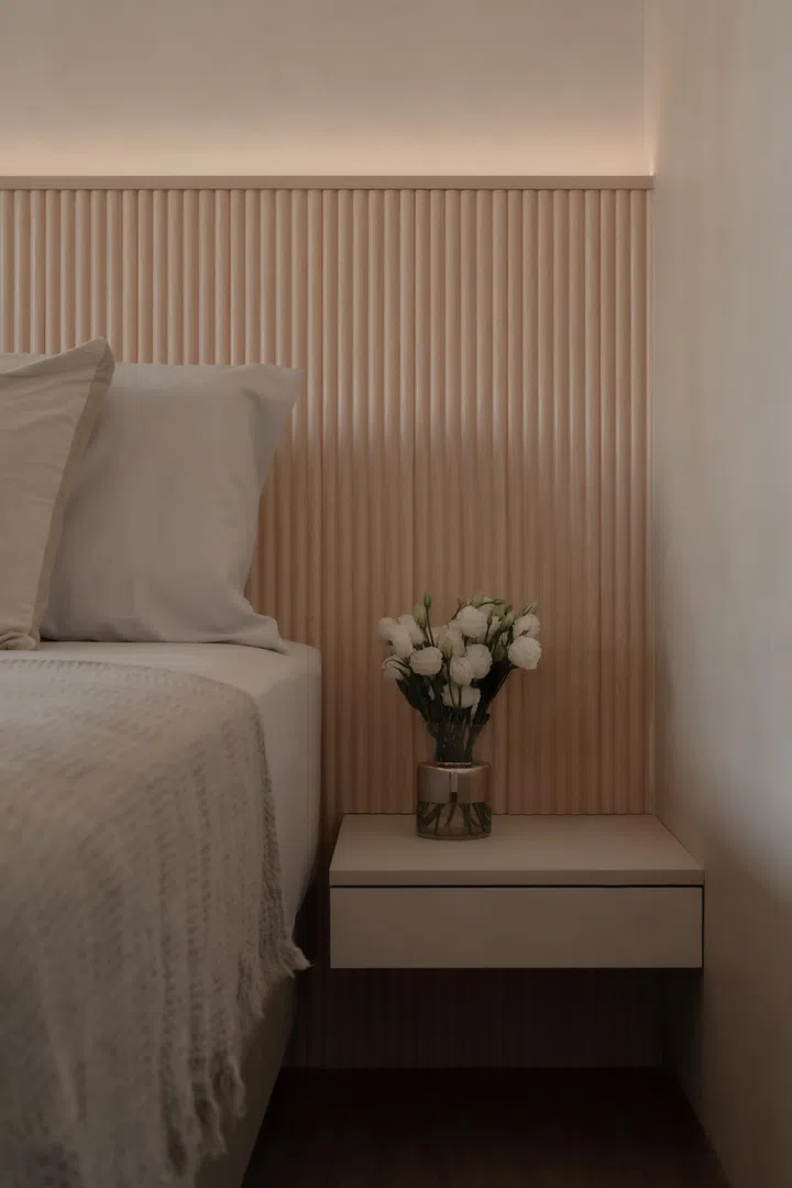 A fluted timber headboard and concealed lighting create a calm, tactile backdrop in the master bedroom, where curves soften into a more restful expression.