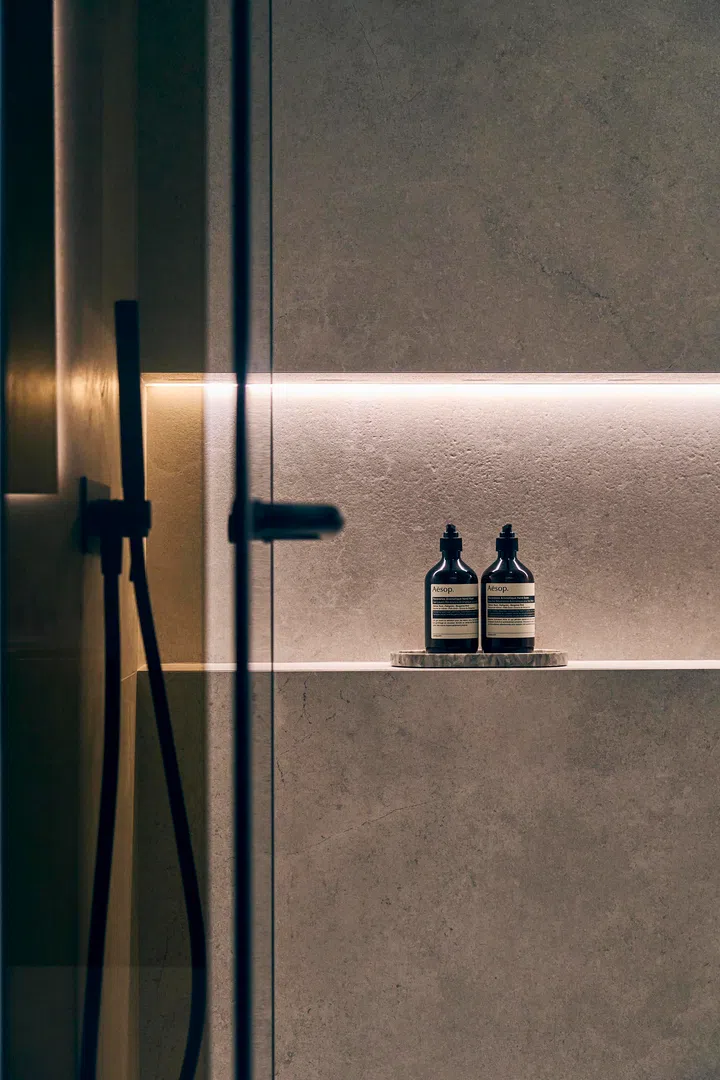  Backlit niches highlight the details—functional storage that doubles as subtle mood lighting.
