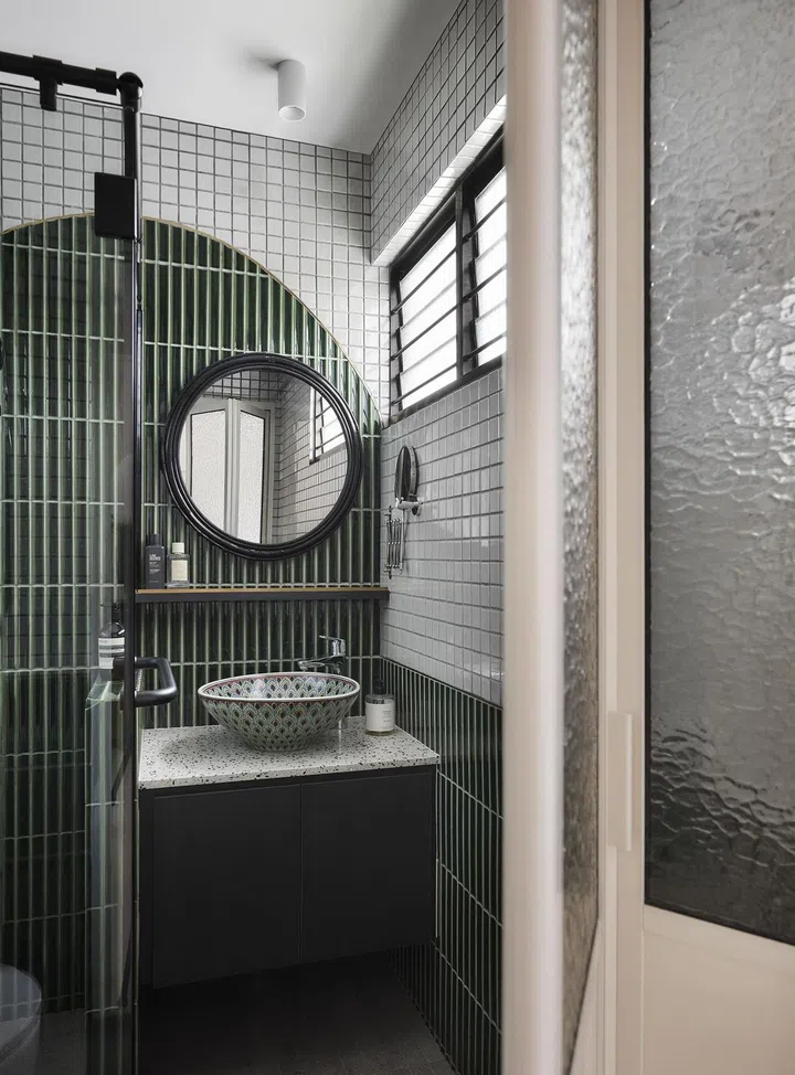 Bamboo tiles and white iridescent Japanese tiles in the bathroom of this 1,367 sq ft 5-room HDB at Bedok Reservoir Road. 
