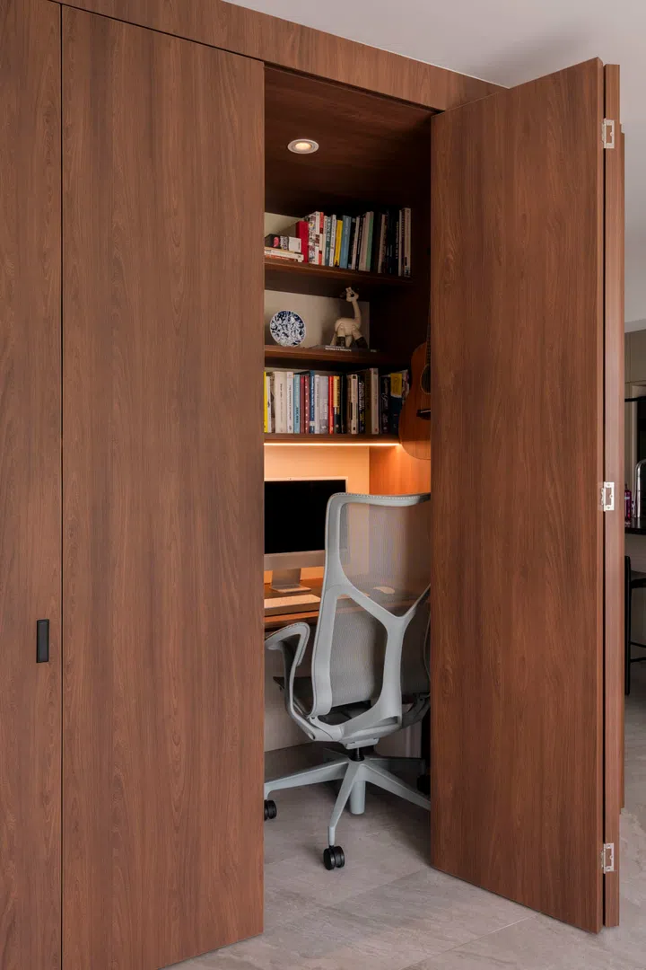 Concealed cabinetry hides away the work desk, keeping clutter out of sight when not in use.
