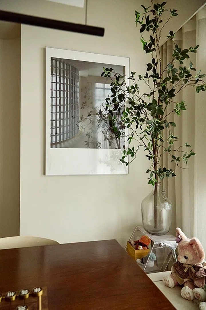 A photograph of the newly completed glass brick wall hangs nearby—a personal record of the moment the house began to feel like his.