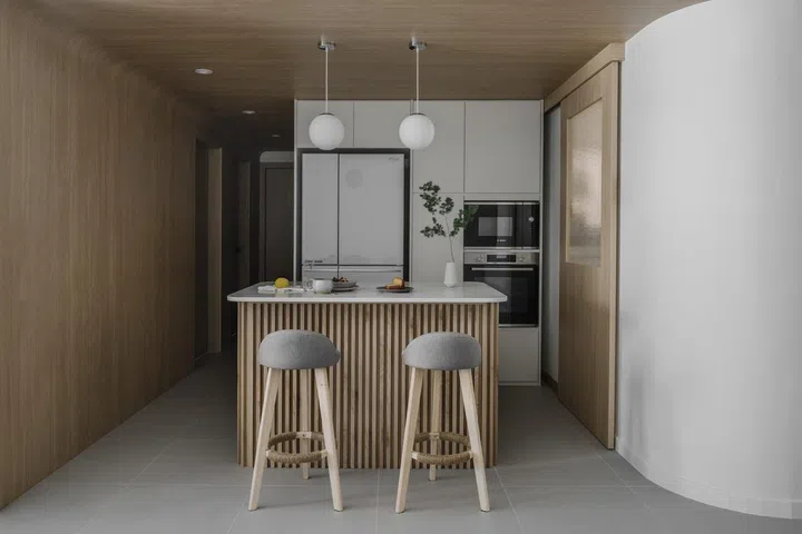 All wood kitchen with a kitchen island dining table in a young lawyer couple's 3-bedroom condominium in Bishan.