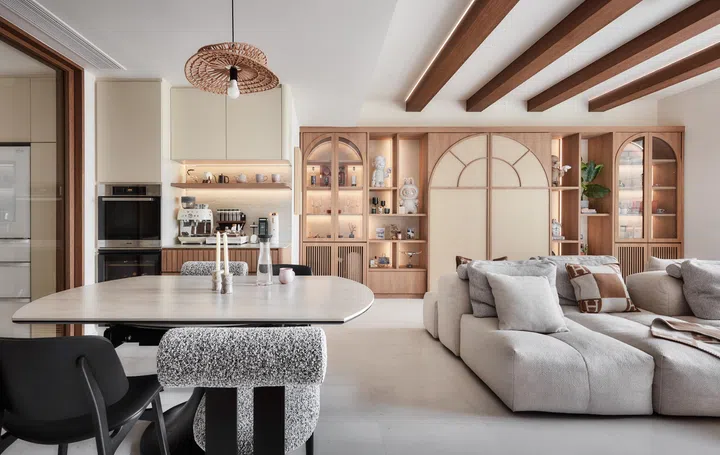 The arched feature wall anchors the living and dining areas, combining open display shelves with concealed storage and a surprise at its centre.