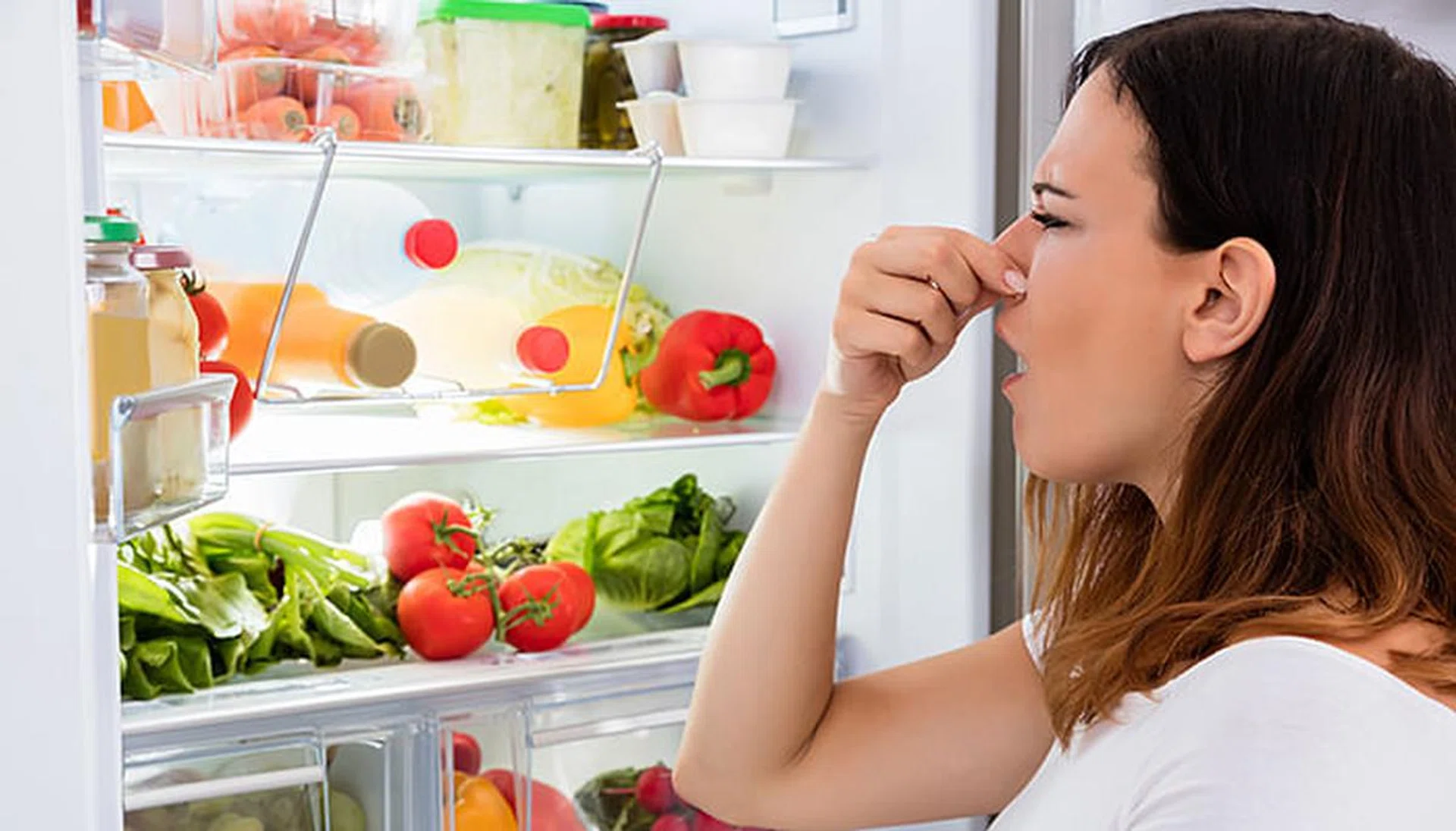 93247-woman-checking-smelly-spoilt-foods-in-fridge