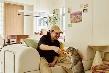 Kai relaxes in the open-plan living area with his cat Monmon.