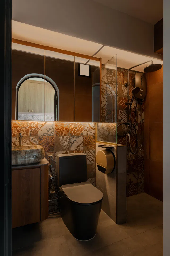 Warm lighting and layered textures transform the bathroom into what Amir likens to “entering a portal, another world.”
