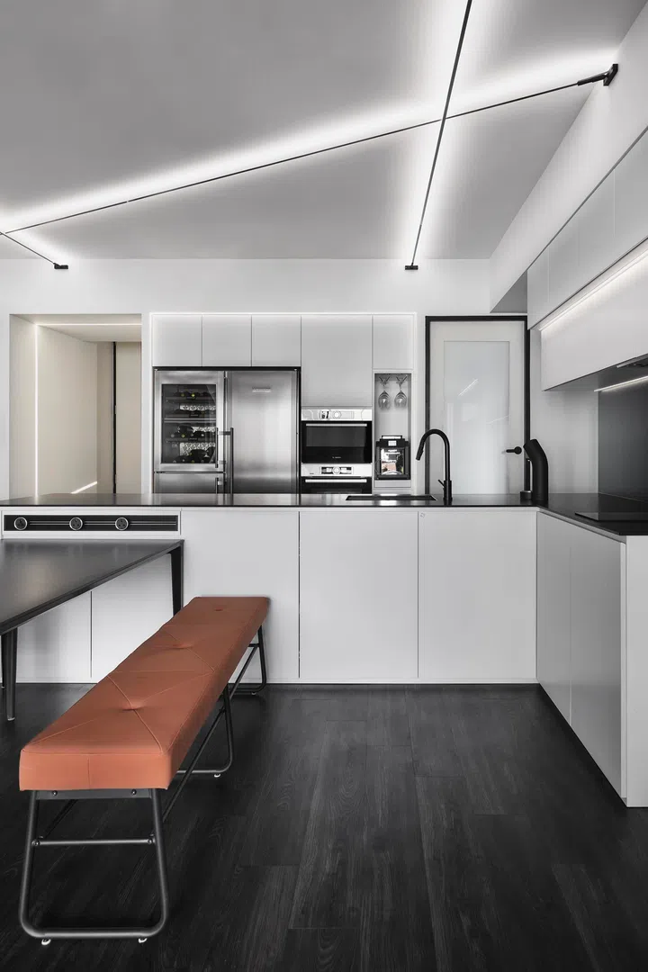 The monochrome palette is softened with tan leathers, balancing warmth against the graphic geometry overhead.