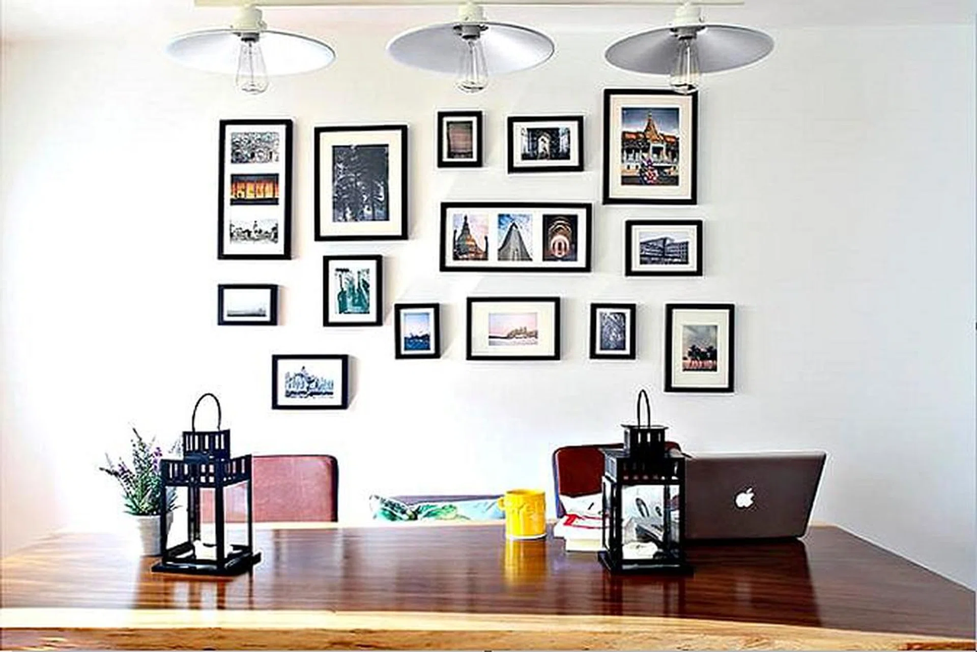 Frames of photographs on a wall behind a dining table