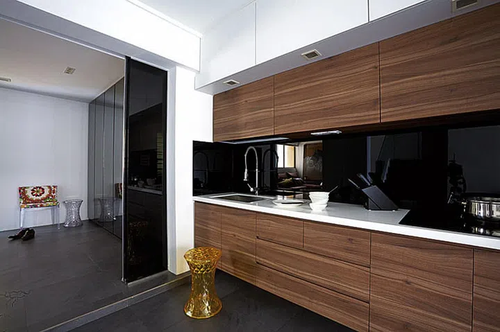 The kitchen walls in this HUDC Maisonette unit in Hougang were replaced with sliding glass doors that lead to the living room – the result is a brighter, more interactive cooking space.