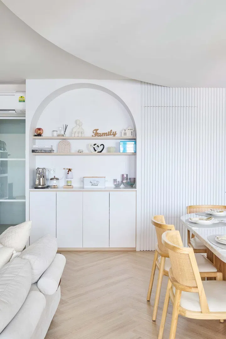 A pantry on the other side elevates a functional purpose into a design element. It has a similar arched profile, which continues into a feature wall with fluted details that conceals the master bedroom door. 