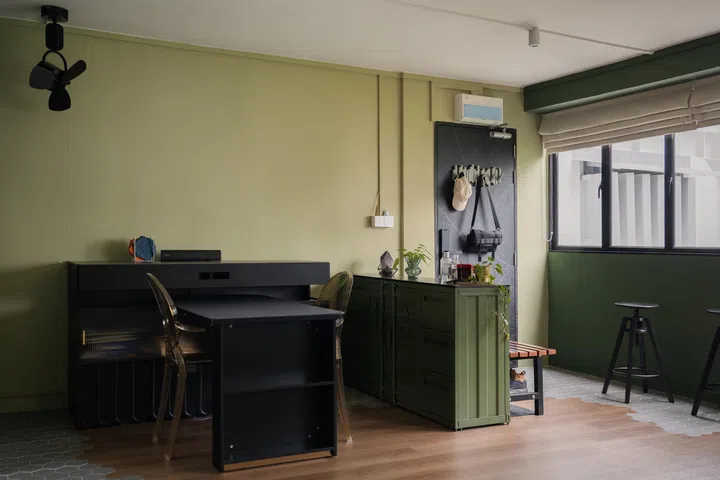A green shipping container cabinet and bench define the foyer, while hexagonal tiles transition playfully into vinyl flooring.