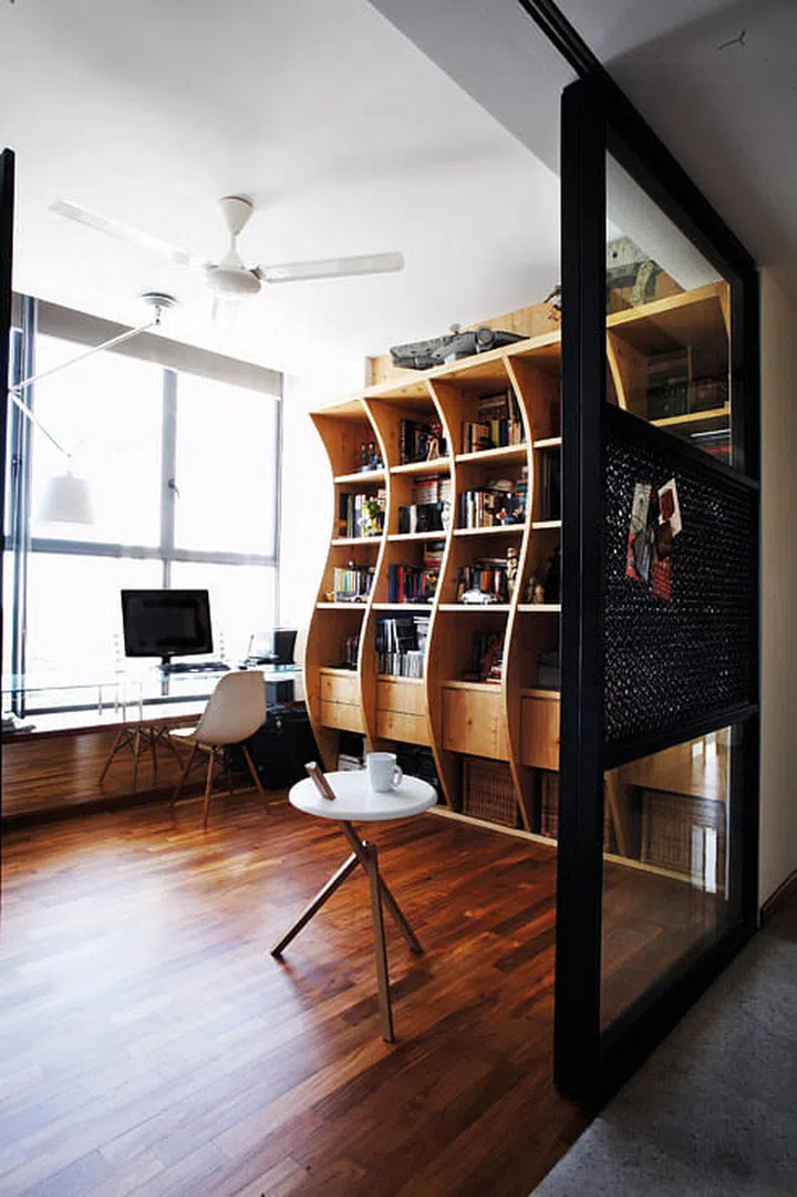 A curved bookshelf breaks the boxiness of the room and gives the space a sense of movement. The study can be closed off completely despite the open weave of the steel mesh as there is a layer of glass sandwiched in between.
