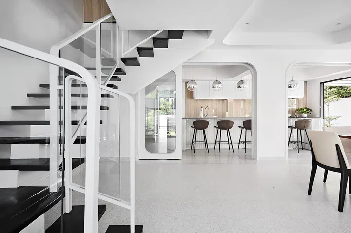 Curved
elements- from
balustrades
and door
frames to the
kitchen island
and ceiling
hollows, create
an interesting
aesthetic and
take their cue
from the existing
form of the
second storey
mezzanine that
overlooks the
living area.