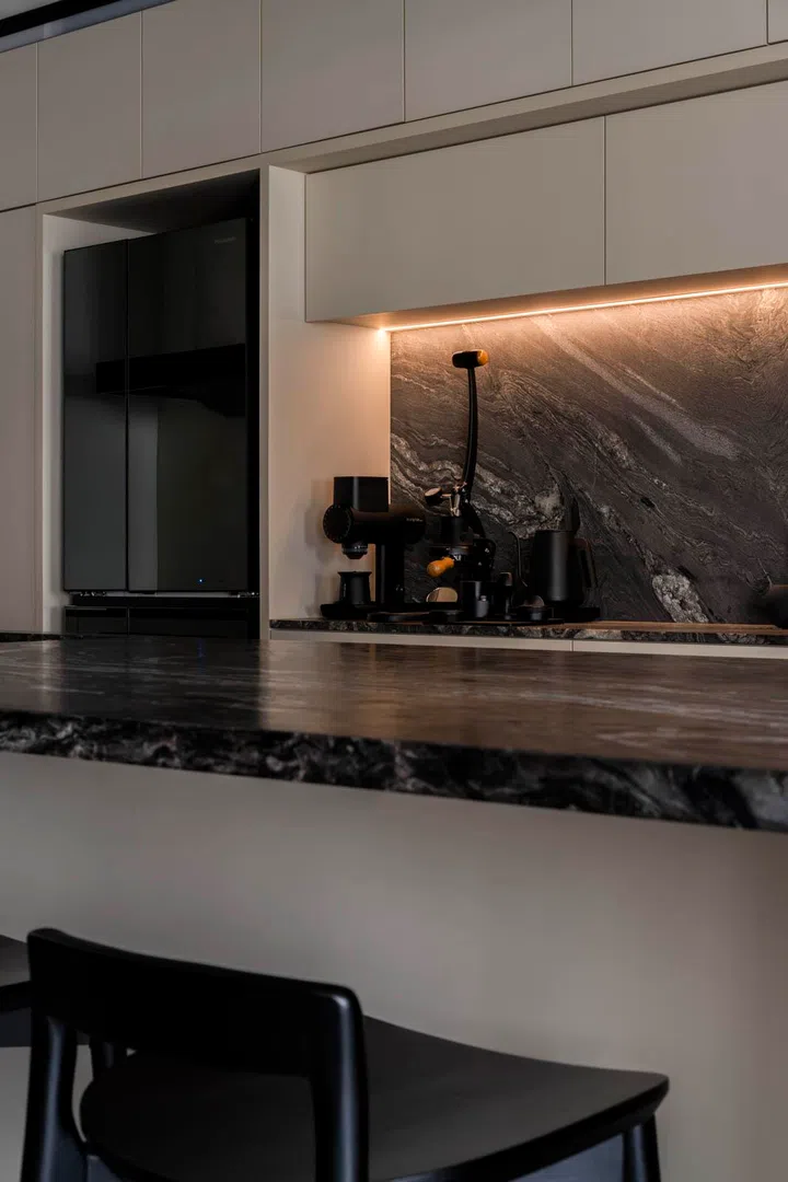 The island doubles as a social hub, with appliances tucked discreetly into the wall behind.