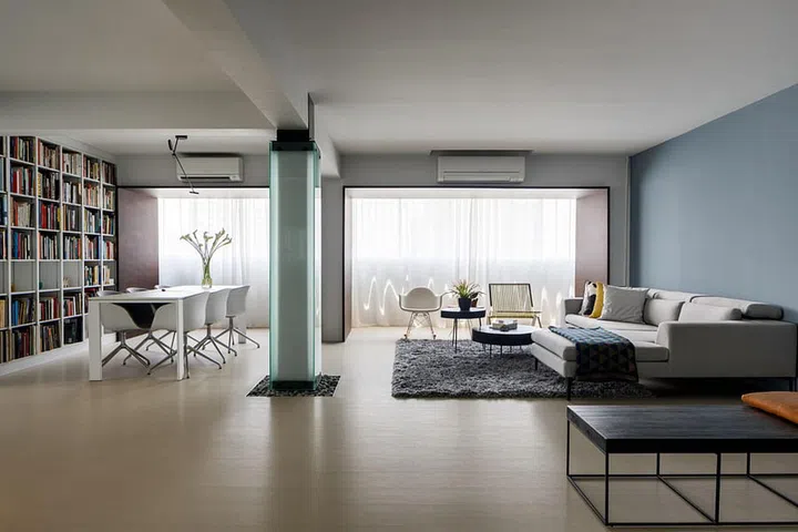 Visitors are drawn to a light column that separates the living and the dining areas, and surrounded by a bed of stones in this architect's Ang Mo Kio house.