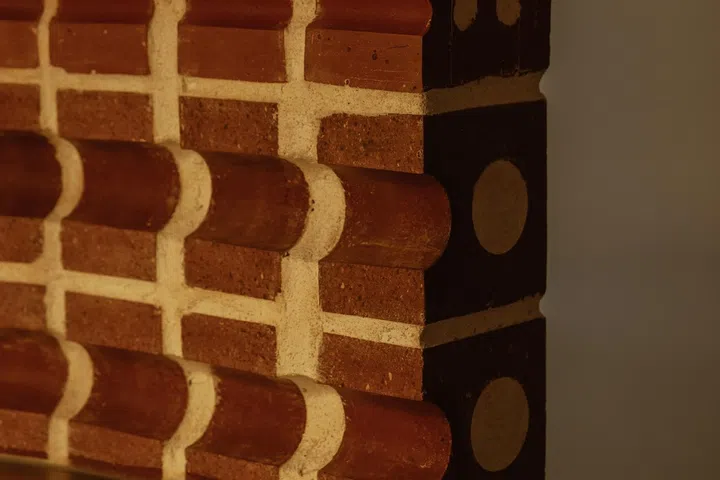 Exposed bullnose bricks drape the walls for the couple’s home bar.