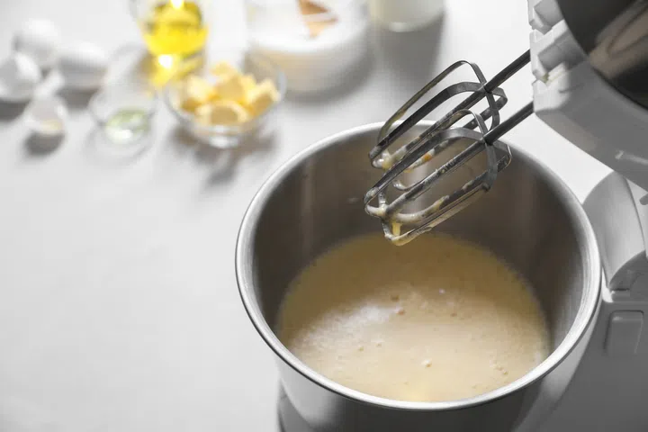 Making dough in bowl of stand mixer on white table. 