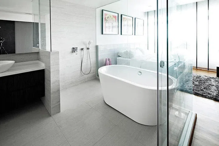 This designer brought the hotel-effect into his bedroom, replacing the ensuite's bathroom wall with glass. The use of gray tiles and stand-alone tub brings an elegant look to the bedroom. Interior design by Rezt & Relax Interior