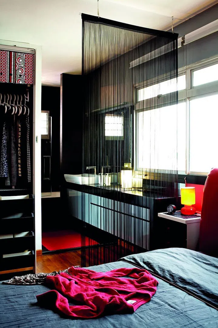 Using a string curtain instead of a solid door to partition off the ensuite bathroom makes the small masterbedroom look and feel more spacious. It also adds a seductive element.