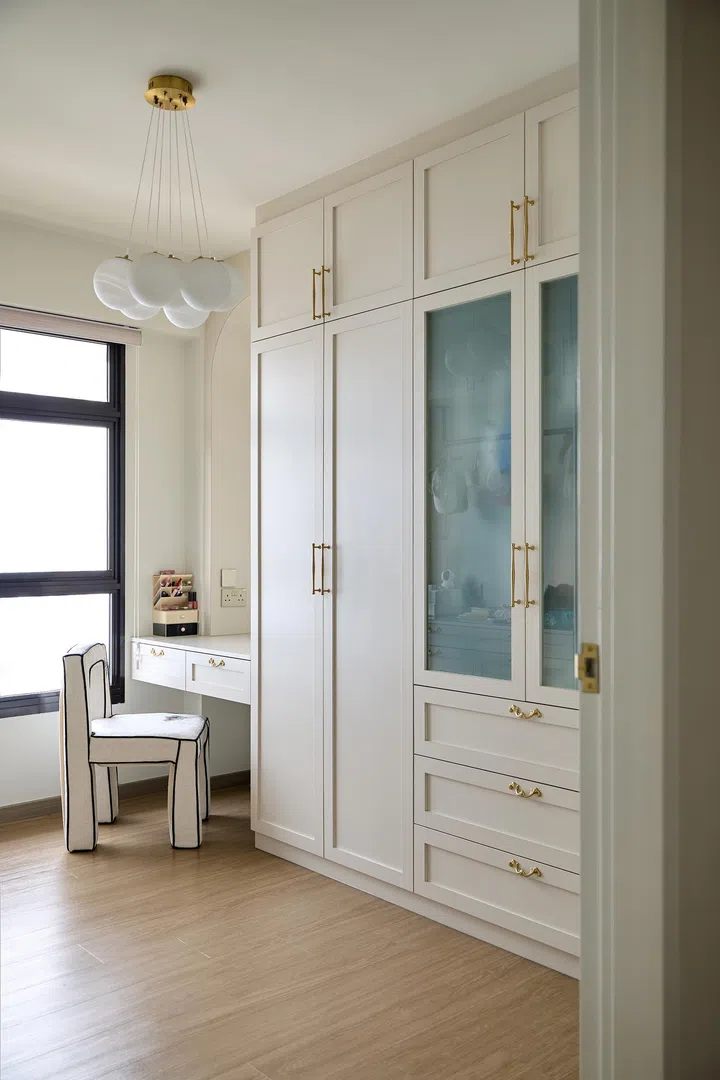 The wardrobe room with storage and a vanity.