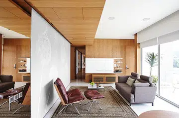 [Renovation cost: $320,000] The homeowner loves the wood-panelled false ceiling in the living area – one of the apartment’s focal points. The TV is concealed in a white painted oak cabinet. The home is styled by Mike Tan of Egg3, using accessories from his shop. William Png's white and wood 3-bedroom condominium off Orchard Road.