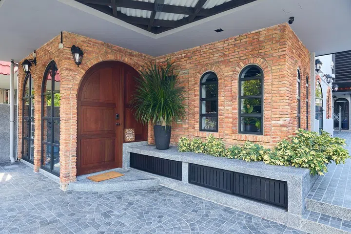 Red bricks and arched windows and door adorn the façade of this 1,189 sq ft single-storey corner terrace house in Siglap.