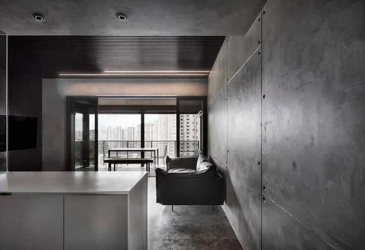 Concrete panels line the living room walls in this Concrete kitchen island in this all black and white 1,184 sq ft 4-bedroom condo in Queenstown.