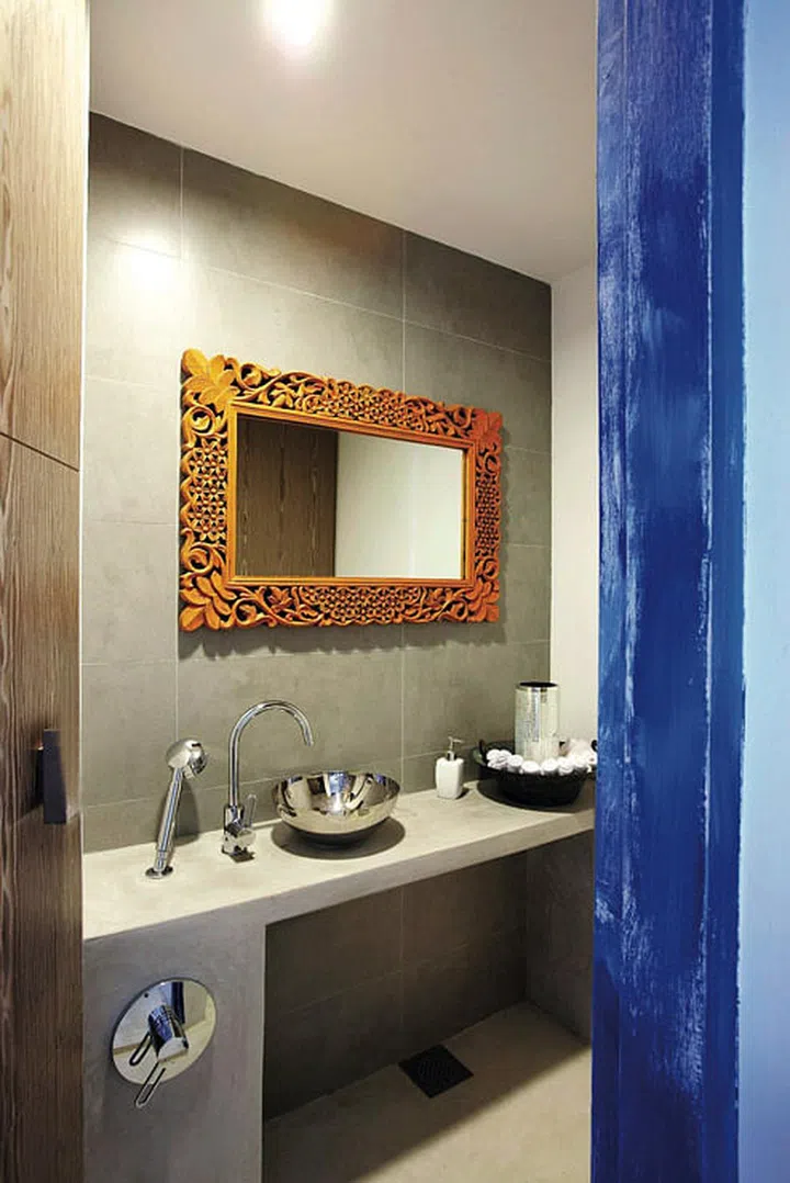 The orange and blue palette is continued in the powder room.