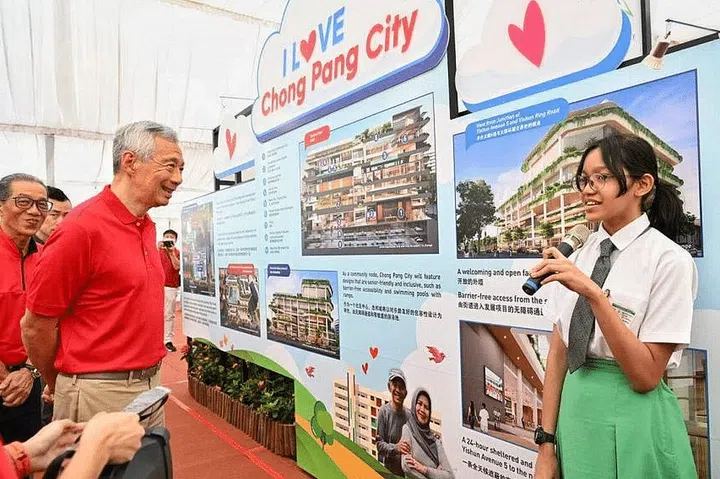 PM Lee Hsien Loong listening to a presentation by Secondary 3 student Putri Wardina Syaurah at the ground-breaking ceremony for Chong Pang City on Sunday. ST PHOTO: CHONG JUN LIANG