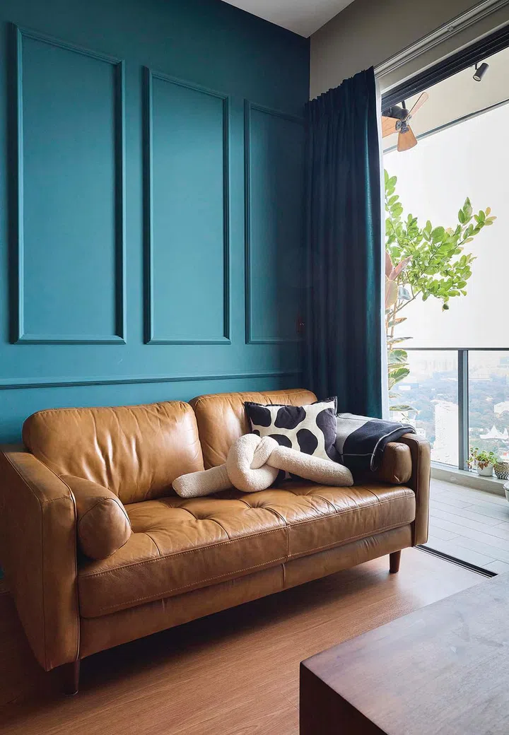 A green wainscoting wall behind the sofa in the living room of interior designer Vivian Chen (of Muwu Construction) and financial advisor husband, Michael Chan's 635 sq ft 2-bedroom condominium along Stirling Road.