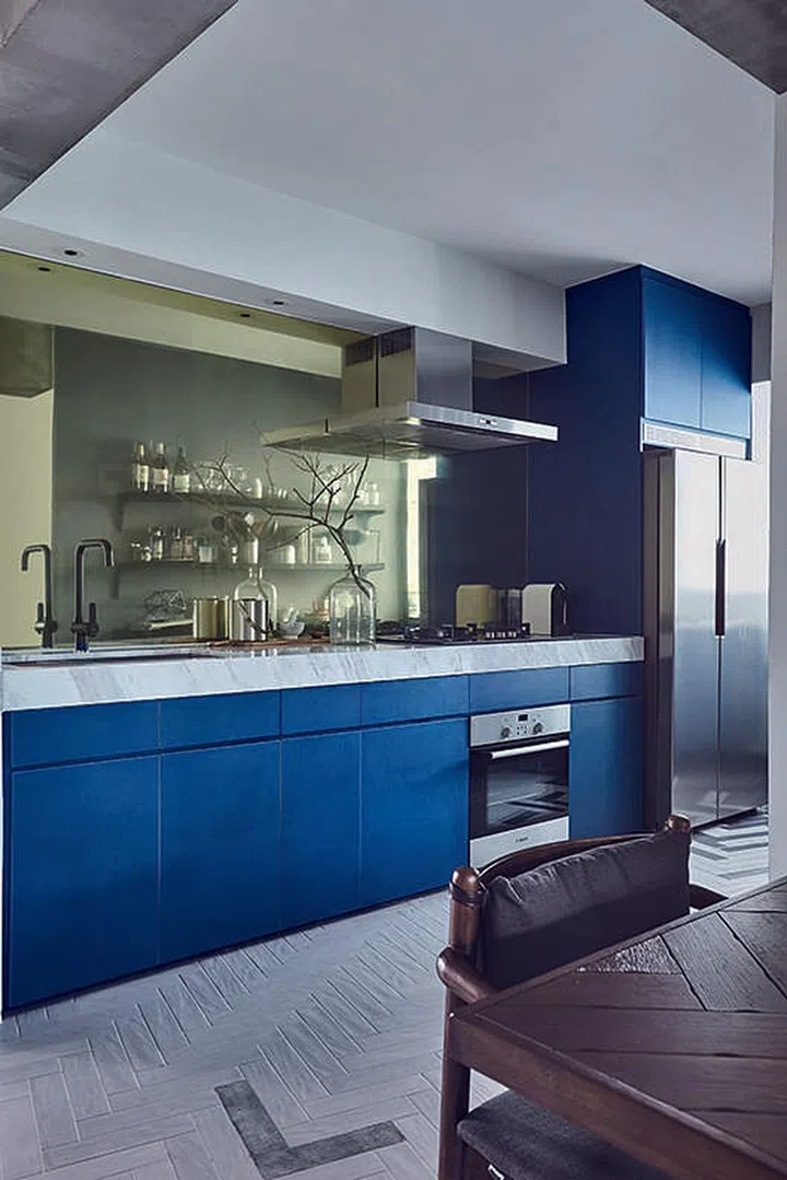 The champagne tinted mirror panels provides an eye- catching contrast to the rough and raw surfaces of the adjacent living area. Interior Design by Bowerman Interior Planner.