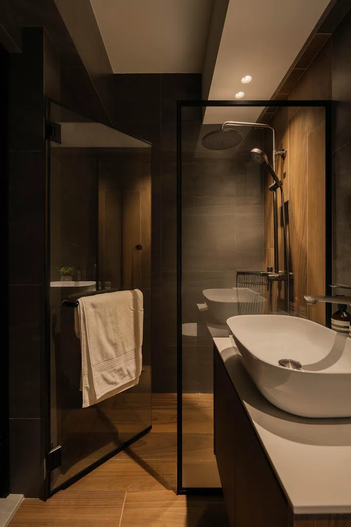  The darker master bathroom, clad in moody tiles and warm wood accents, creates an enveloping and intimate feel.
