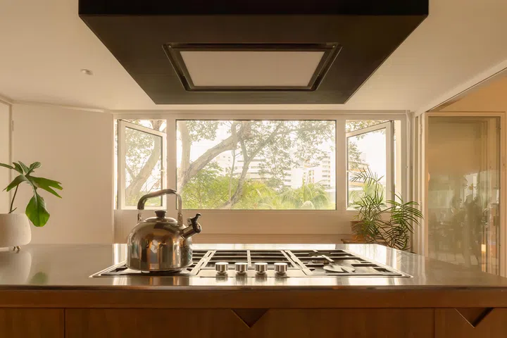 The stove on the island faces outward, allowing the hosts to cook while engaging with guests—or simply enjoying the view.