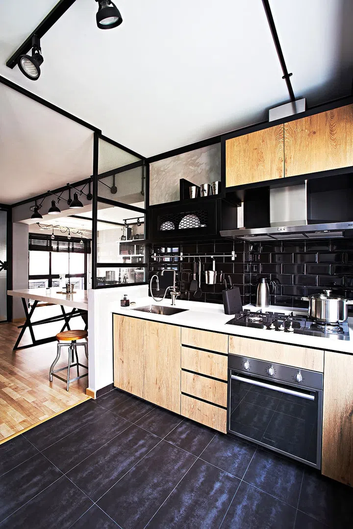 Black and wood kitchen cabinets and black tile kitchen backsplash. Black tile floor. Interior design by Space Sense.