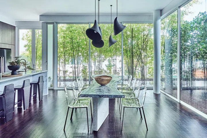用餐区以落地玻璃取代实墙，引进户外绿意以及自然光，让光影为空间增添诗意。