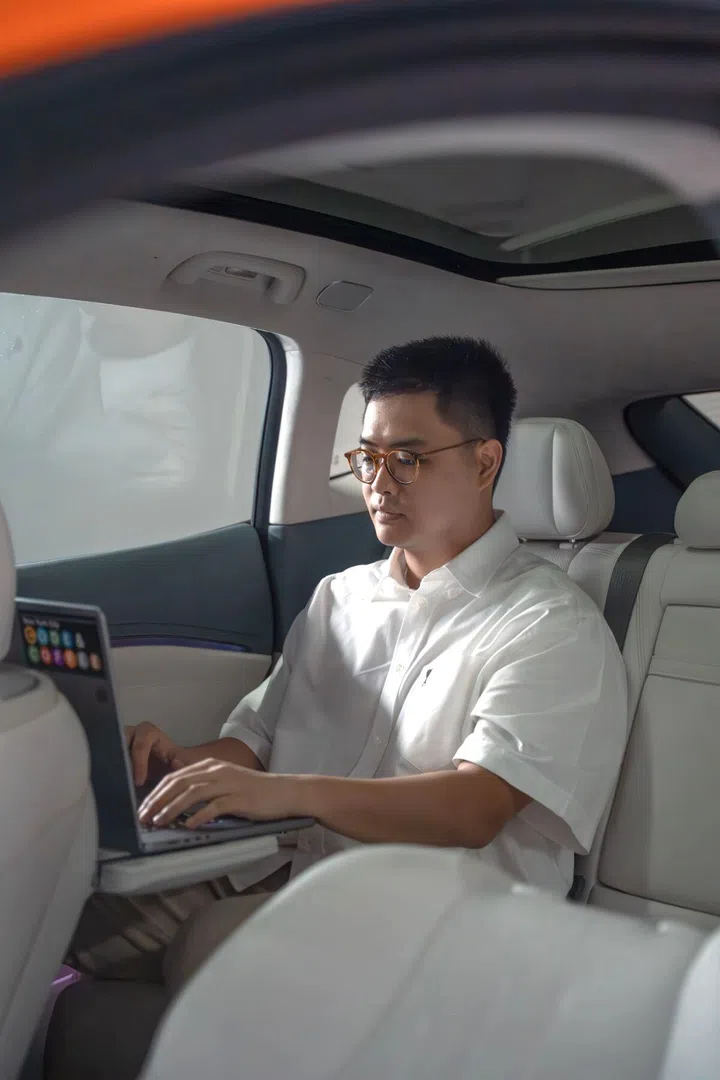 Ernest Tan working on a laptop in the spacious rear cabin of the GAC Hyptec HT.