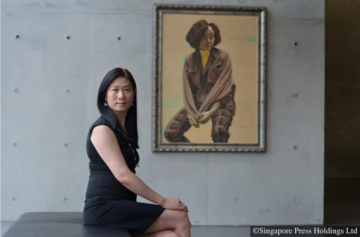 Art collector Wang Wei sitting next to the painting, 'Beige Portrait' by Yu Hong, at Long Museum West Bund.