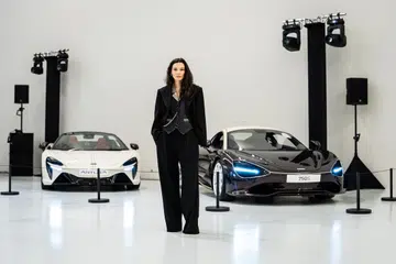 Chelsea Scott-Blackhall stands in front of the McLaren 750S Coupe and Artura Spider, created for the Project Duality collaboration between DZOJCHEN and McLaren Singapore.