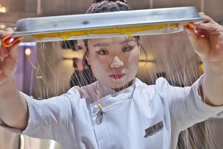中式料理厨师郑智善在比赛中制作“拔丝”菜肴。（Netflix提供）