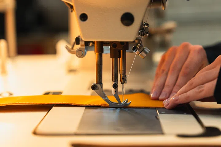 MSO craftsmanship in action as a sewing machine stitches a leather piece for a bespoke McLaren interior.