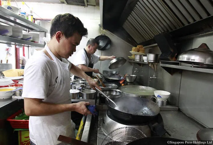 Chefs busily cooking various dishes at zi char eatery Kok Sen Restaurant in Keong Saik Road.