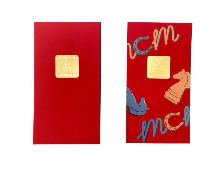 MCM 2026马年红包封正反面设计展示，红包封整体采用鲜红色底色，呈现简洁而醒目的视觉效果。正面中央为金色金属质感徽章，上方刻有“MCM”品牌标志及“MÜNCHEN”，下方印有“M1976”字样，展现品牌经典身份象征。背面则融入趣味插画元素，包括马头、马蹄铁以及棋子造型的马术图案，并搭配“MCM”字样设计，整体风格活泼现代。红包封设计融合品牌标志性元素与马年主题，展现富有创意与时尚感的新年视觉风格。2026马年红包封盘点：今年的新年红包设计，你最喜欢哪一个？