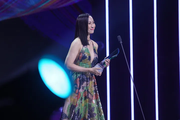 《红星大奖2026》现场，蔡琦慧身穿彩色礼服手持奖座在台上领奖，站在麦克风前微笑致意，背景灯光柔和，记录她荣获“十大最受欢迎女艺人”的高光时刻。《红星大奖2026》从“听牌”晋升超级红星的蔡琦慧