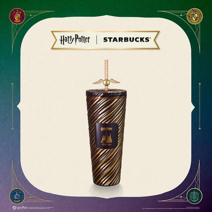 Starbucks与Harry Potter联名随行杯，杯身采用深棕与金色螺旋纹设计，中央印有Hogwarts城堡图案，搭配金色飞贼造型吸管装饰，整体呈现魔法主题。背景以学院元素点缀四角，呼应Hogwarts四大学院，展现经典魔法世界与日常咖啡配件的结合。