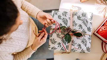 圣诞礼物包装小技巧示意图：以简约圣诞包装纸、麻绳与松果装饰礼盒，搭配自然元素与缎带细节，示范如何用简单心思提升圣诞礼物包装质感与仪式感。