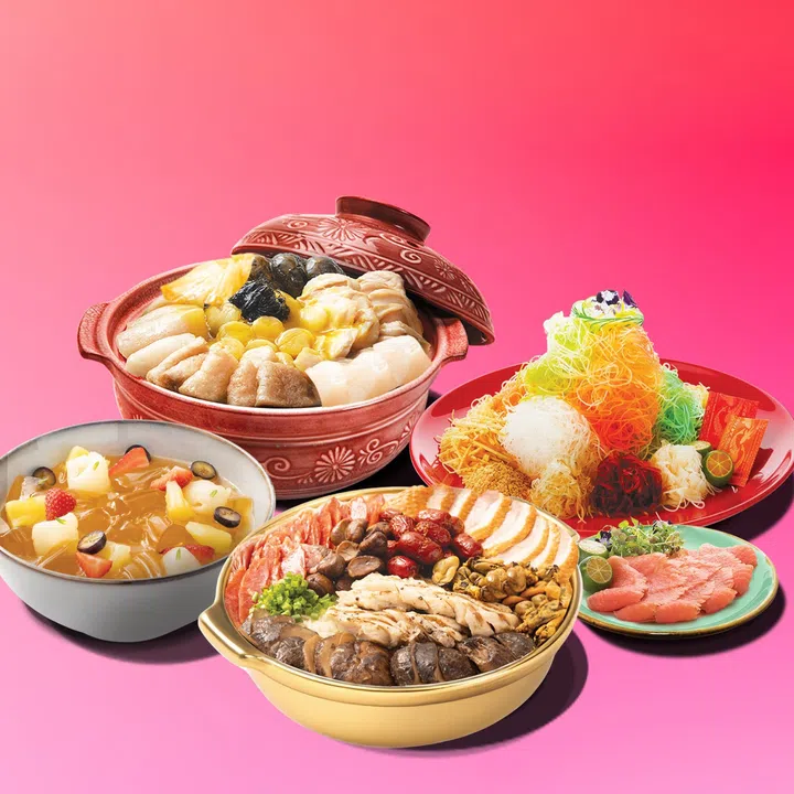 农历新年外带年菜组合展示图，粉红色背景前摆放多款节庆佳肴，包括一锅装满鲍鱼、花胶、带子与蔬菜的盆菜砂锅；一盘色彩缤纷、堆成小山状的捞起鱼生，配有红萝卜丝、白萝卜丝、青菜丝、脆饼与酱包；一锅铺满烧肉、鸡肉、香菇与腊味的团圆煲；旁边另有三文鱼片配青柑橘，以及一碗水果甜品，整体呈现适合家庭聚餐的新加坡农历新年外卖年菜与团圆饭氛围。